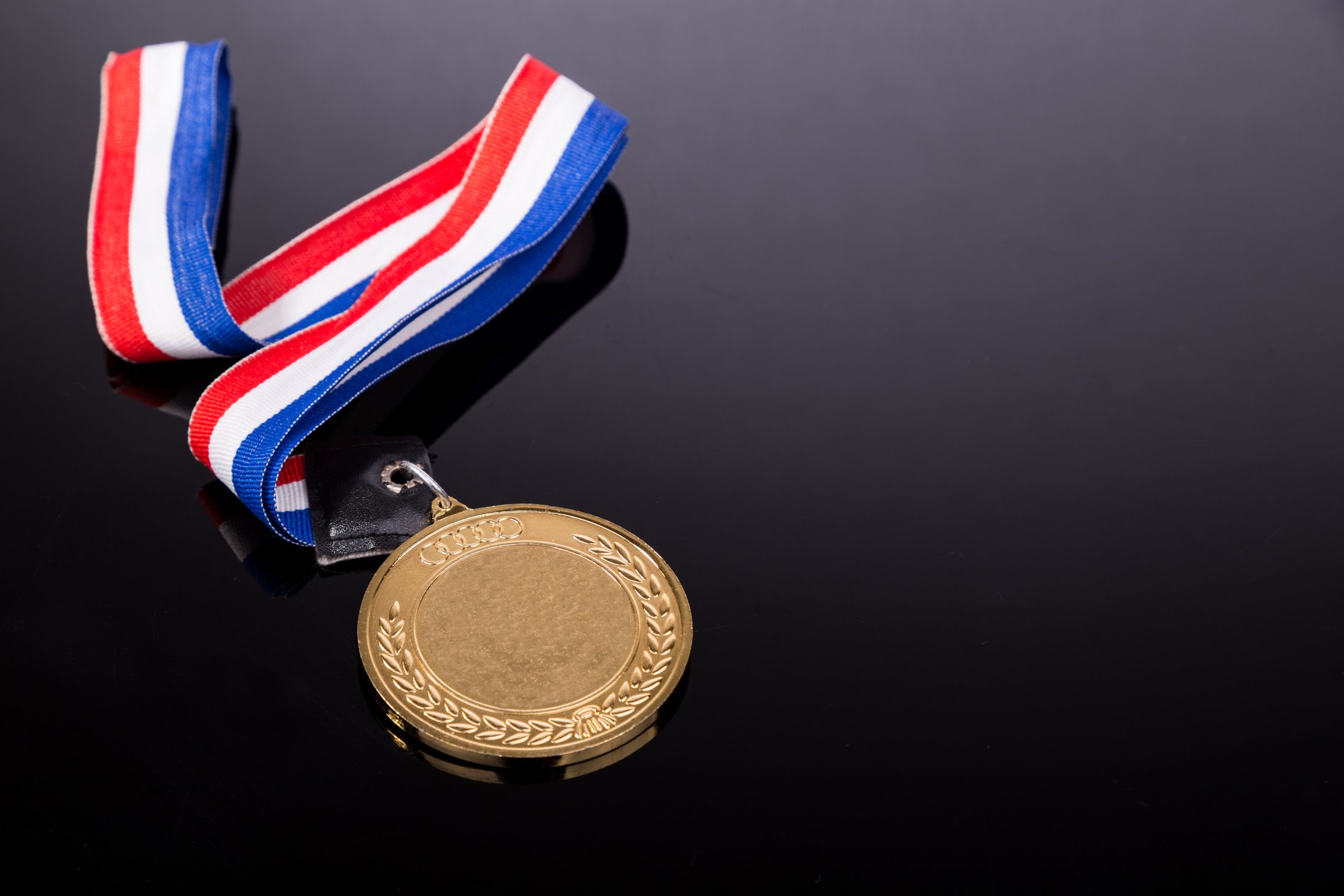 Generic sporting event gold medal with red and blue ribbon